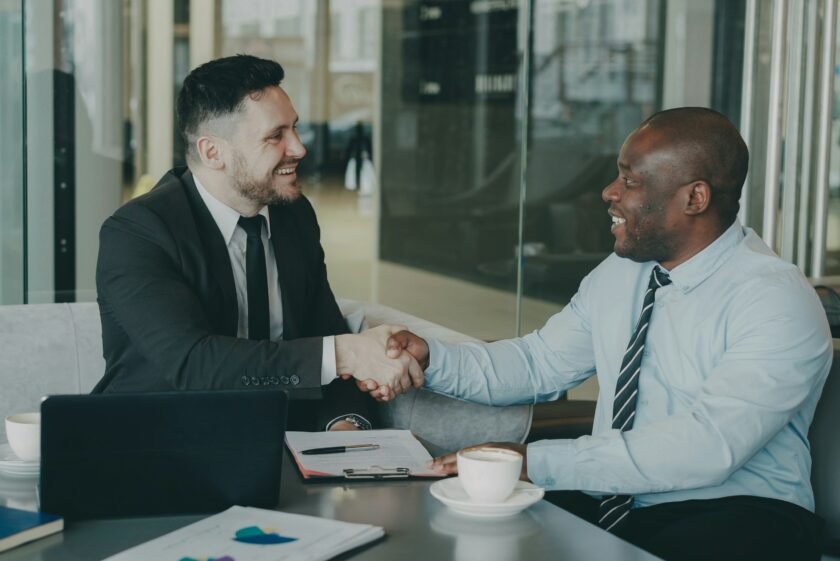 Two business colleagues reviewing a vendor evaluation checklist during an outsourcing partner meeting
