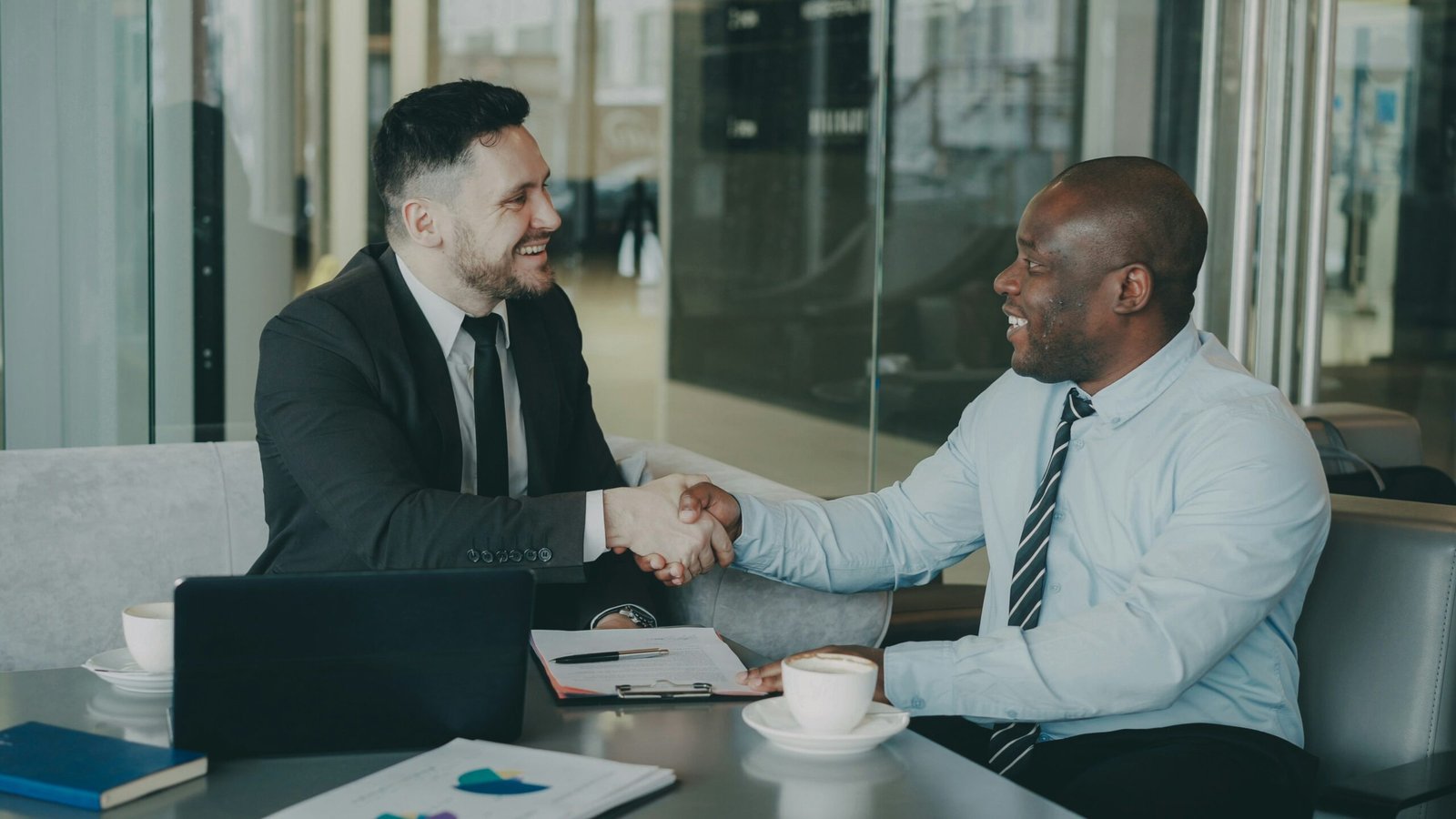 Two business colleagues reviewing a vendor evaluation checklist during an outsourcing partner meeting