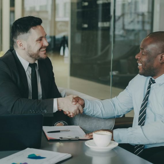 Two business colleagues reviewing a vendor evaluation checklist during an outsourcing partner meeting